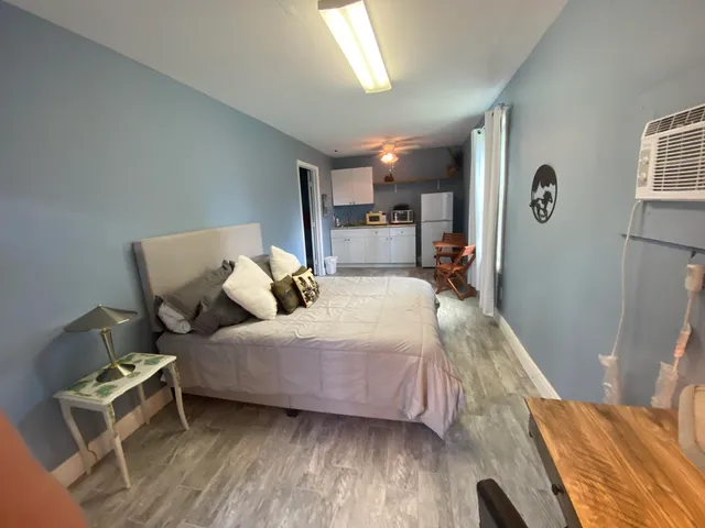 a bedroom with a bed and wooden floor