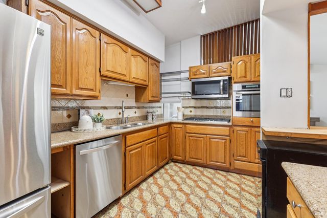 a kitchen with stainless steel appliances granite countertop a sink and cabinets