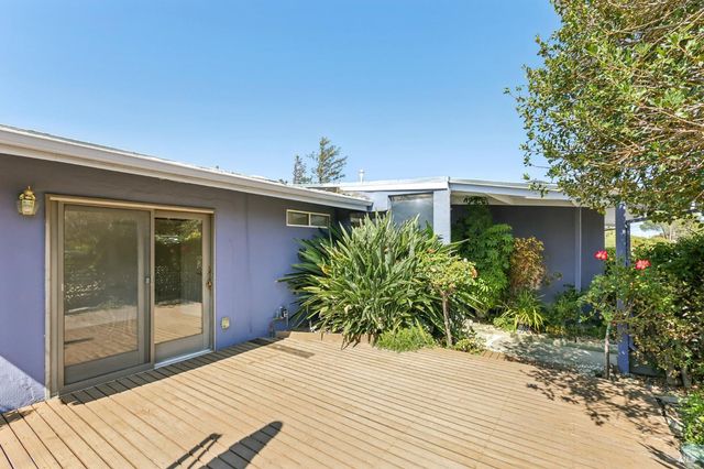 a view of a porch with a table and chairs next to a yard