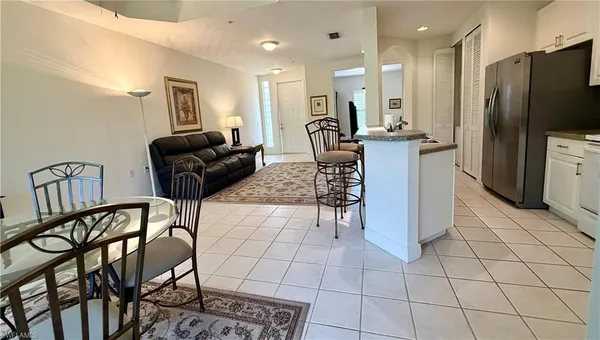 a living room with furniture a dining table and a refrigerator
