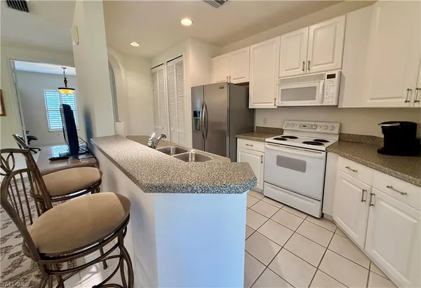 a kitchen with stainless steel appliances granite countertop a white cabinets and a stove