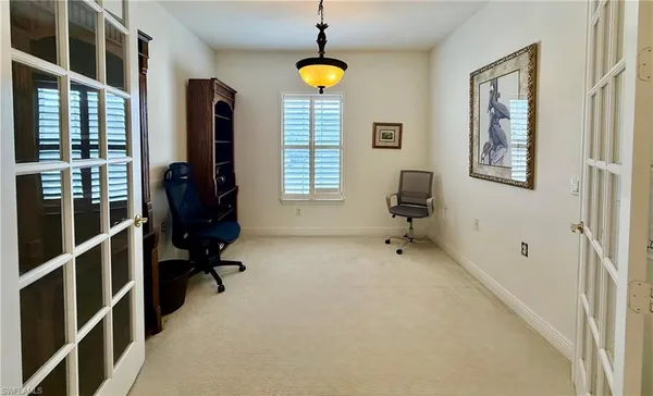 a view of a workspace with furniture and a window