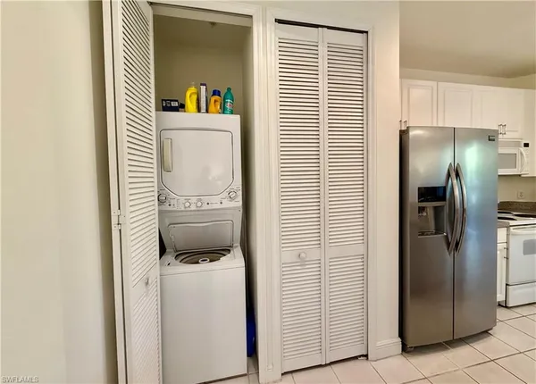 a bathroom with a refrigerator and a washing machine
