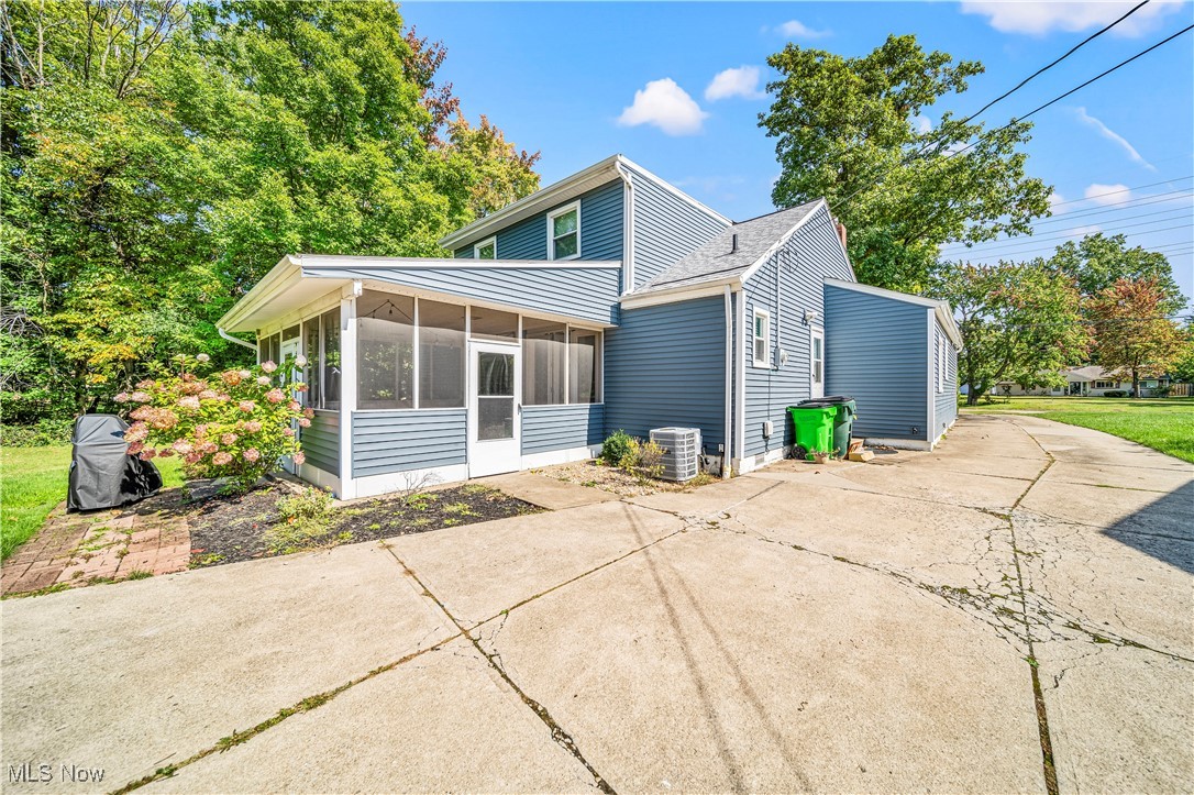 1796 Lander Road Mayfield Heights, OH 44124 - Photo 34 of 39 Back of property featuring a sunroom, a patio area, and central AC