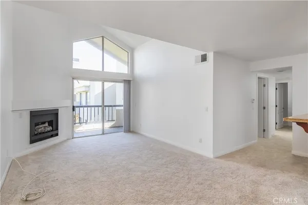 an empty room with a fireplace and windows