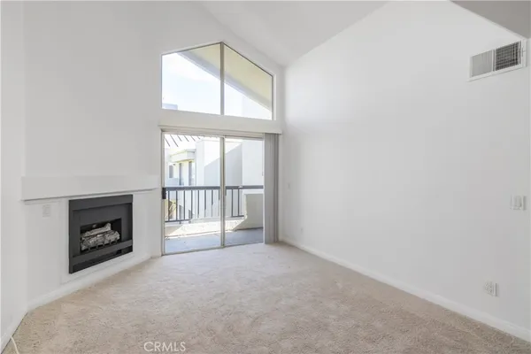 an empty room with fireplace and windows