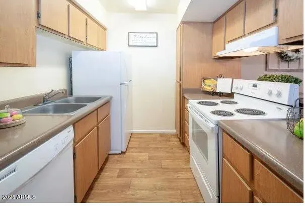 a kitchen with granite countertop a sink stove and refrigerator