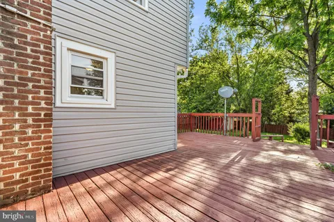 a view of a backyard with wooden fence and large trees