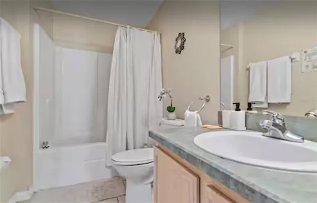 a bathroom with a granite countertop sink a toilet and shower