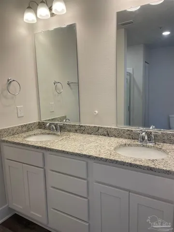 a bathroom with a granite countertop sink and a mirror