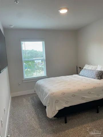 a large bed sitting in a bedroom next to a window