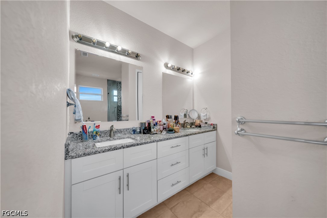 384 Neighborly Road LaBelle, FL 33935 - Photo 22 of 45 a bathroom with a double vanity sink and a mirror