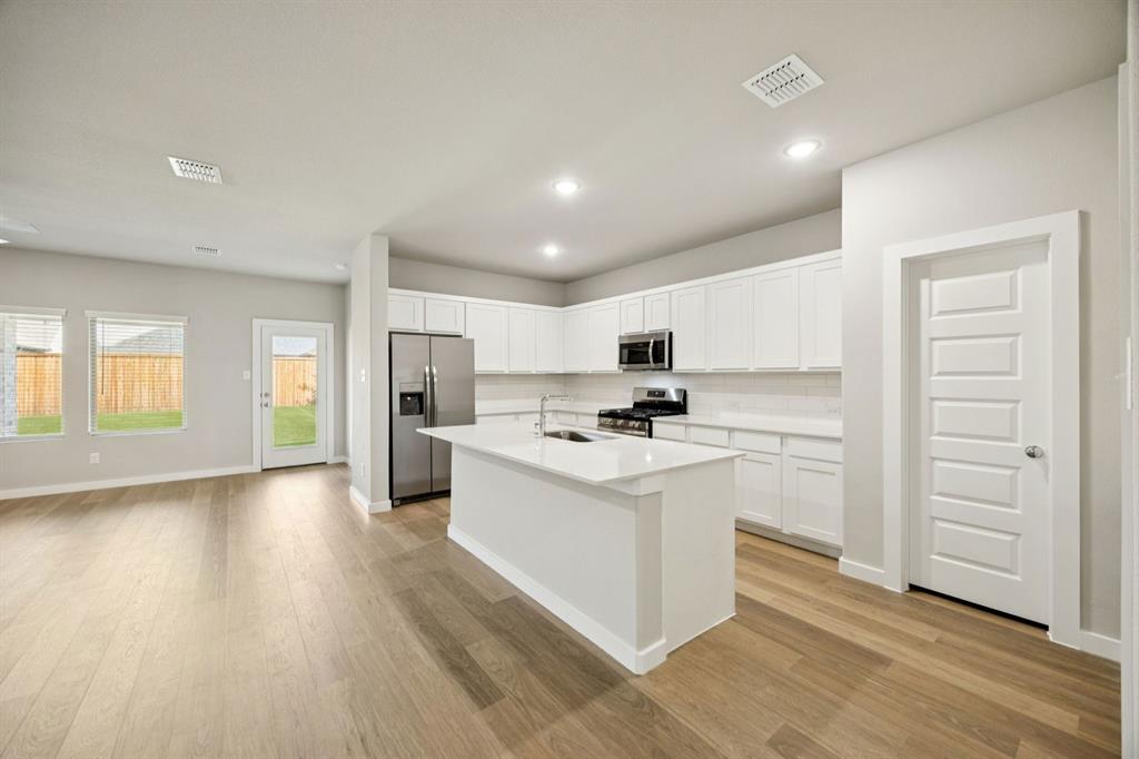 1195 Little Hls Way Lavon, TX 75166 - Photo 8 of 29 a kitchen with white cabinets and stainless steel appliances