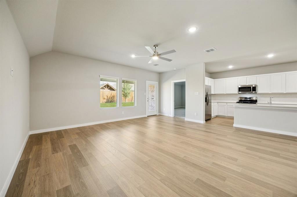 1195 Little Hls Way Lavon, TX 75166 - Photo 28 of 29 an empty room with wooden floor kitchen view and windows