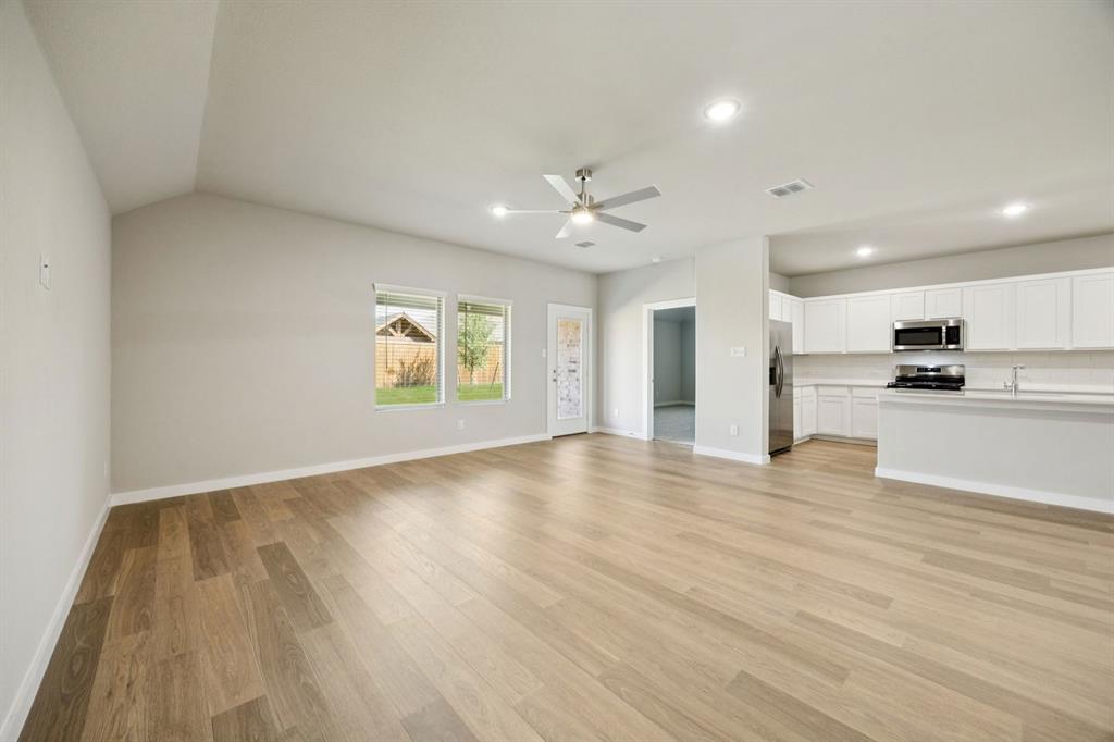 1195 Little Hls Way Lavon, TX 75166 - Photo 28 of 29 an empty room with wooden floor kitchen view and windows