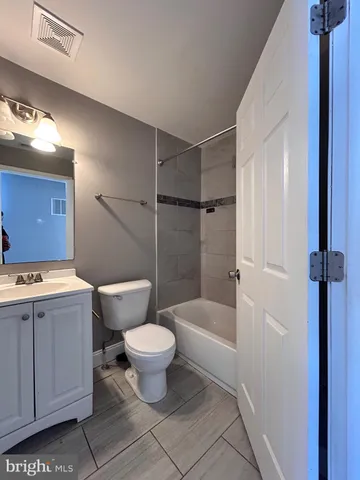a bathroom with a sink toilet a mirror and bathtub