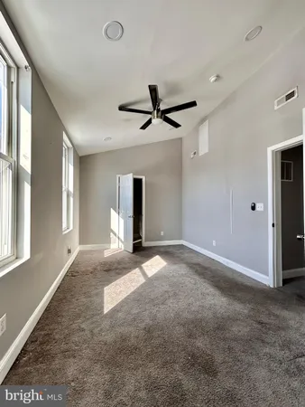 a view of a livingroom with a ceiling fan and window