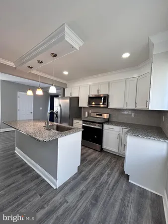 a kitchen with stainless steel appliances kitchen island granite countertop a stove a sink and a refrigerator