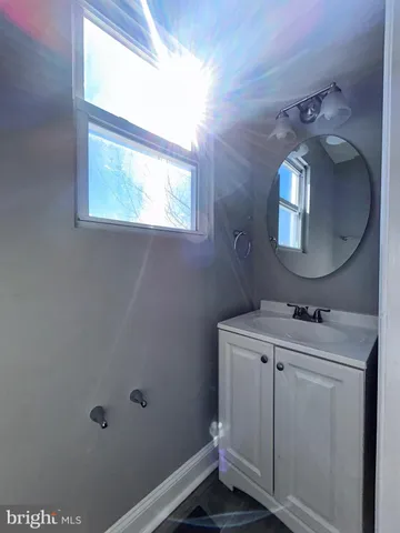 a bathroom with a toilet sink vanity and mirror