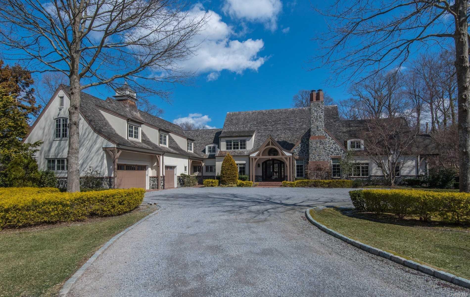 a front view of a house with a garden and trees
