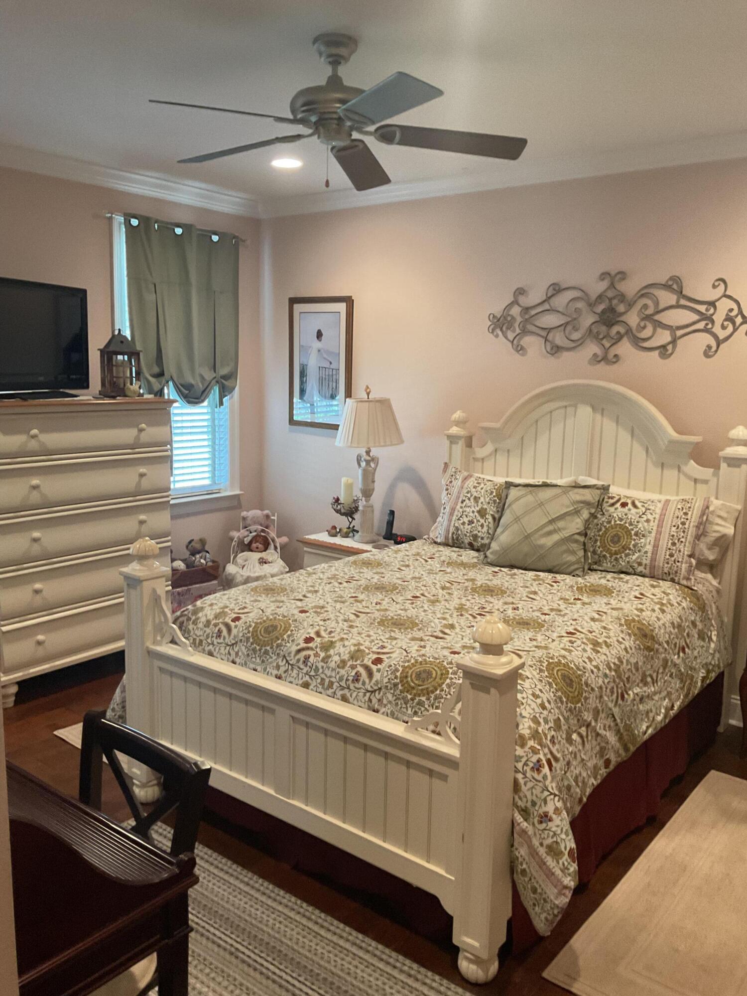 55 Derby Downs Circle Niceville, FL 32578 - Photo 27 of 34 a bedroom with a large bed and a chandelier