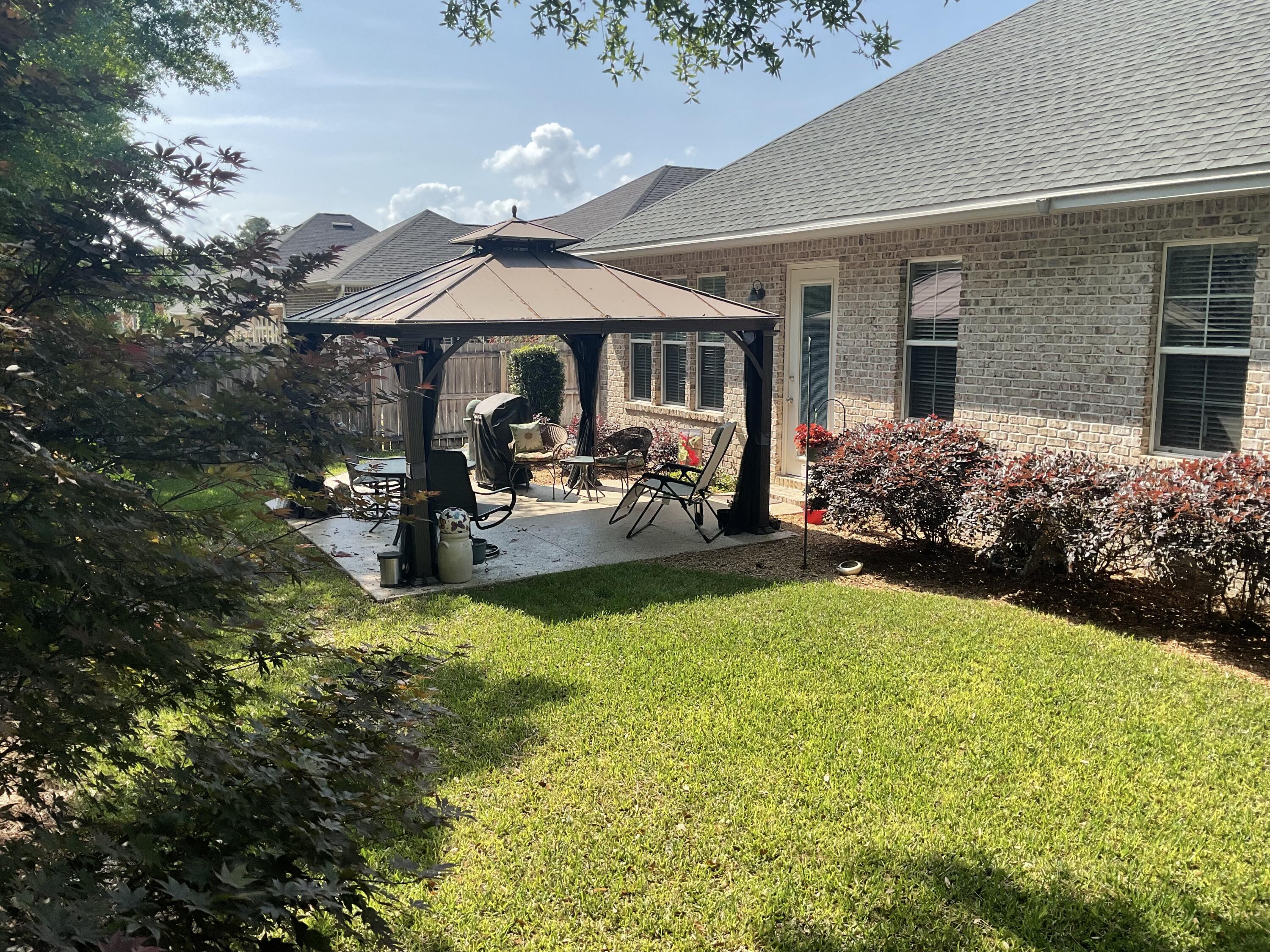 55 Derby Downs Circle Niceville, FL 32578 - Photo 8 of 34 a view of a patio with table and chairs under an umbrella