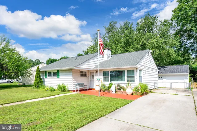 a front view of a house with a garden and yard