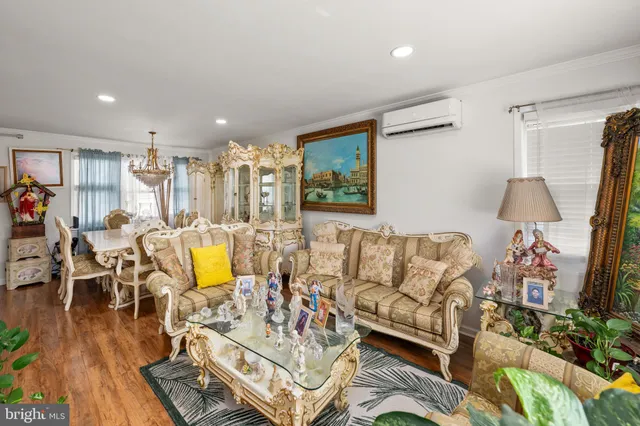a living room with furniture kitchen view and a wooden floor
