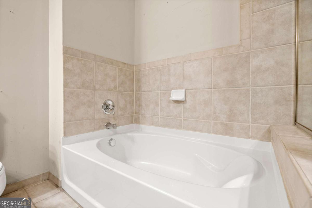 711 Cosmopolitan Drive Northeast, Unit 442 Atlanta, GA 30324 - Photo 13 of 32 a white bath tub sitting in a bathroom