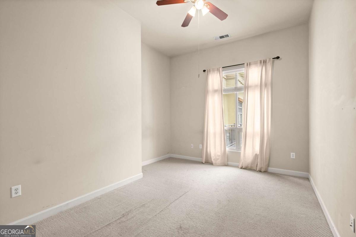 711 Cosmopolitan Drive Northeast, Unit 442 Atlanta, GA 30324 - Photo 17 of 32 an empty room with a empty space and a ceiling fan