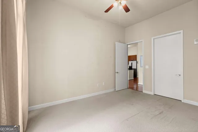 an empty room with closet and a chandelier fan