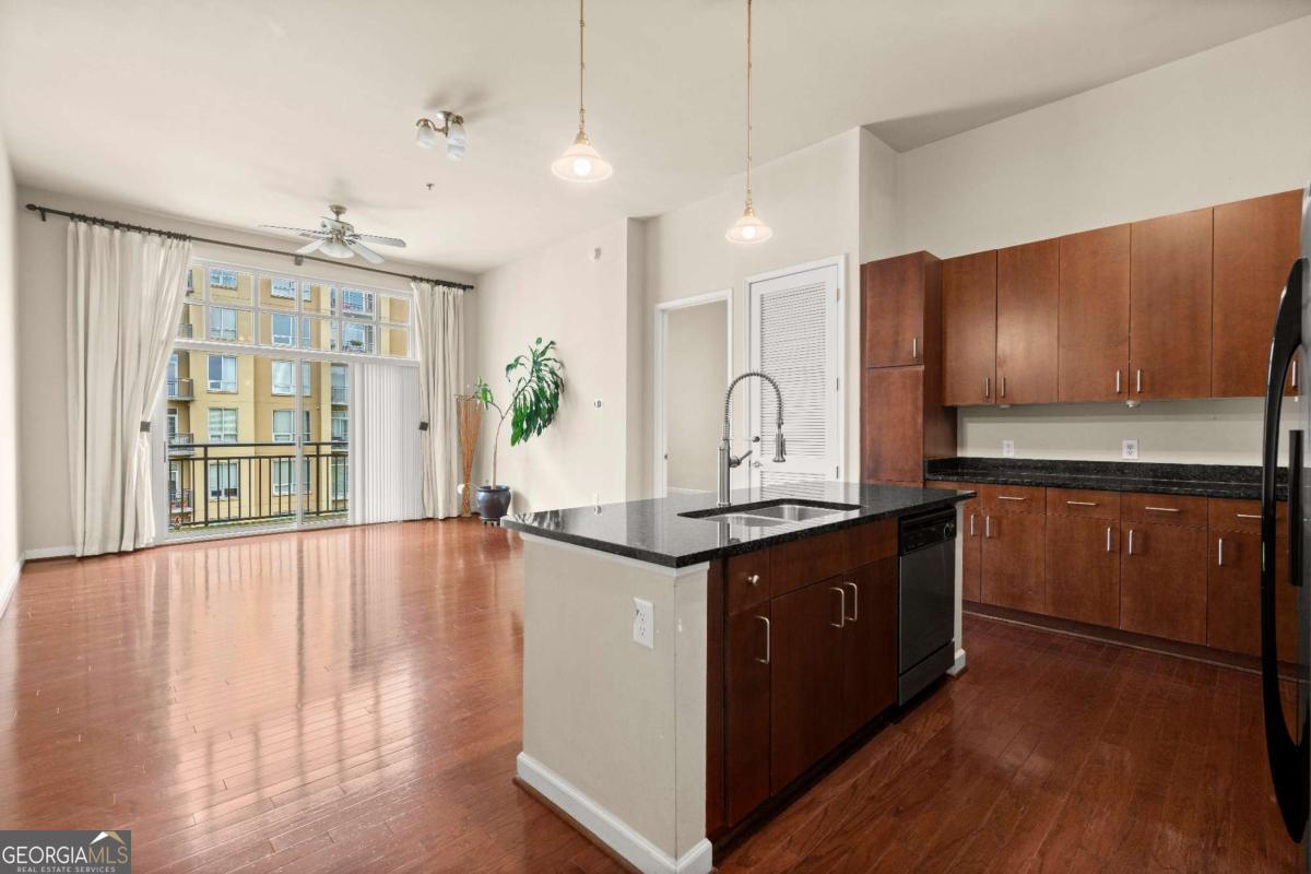 711 Cosmopolitan Drive Northeast, Unit 442 Atlanta, GA 30324 - Photo 2 of 32 a large kitchen with stainless steel appliances granite countertop a stove and a wooden floors