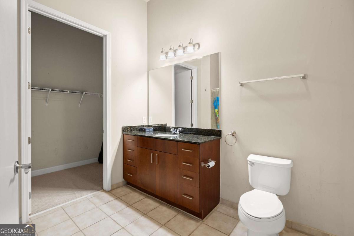 711 Cosmopolitan Drive Northeast, Unit 442 Atlanta, GA 30324 - Photo 21 of 32 a bathroom with a toilet a sink and a mirror