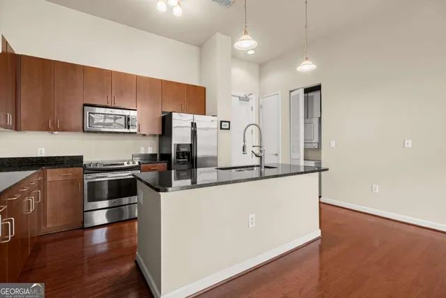 a kitchen with stainless steel appliances a refrigerator and a stove top oven