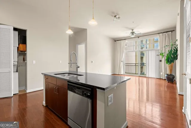 a kitchen with stainless steel appliances granite countertop a sink stove and wooden floor