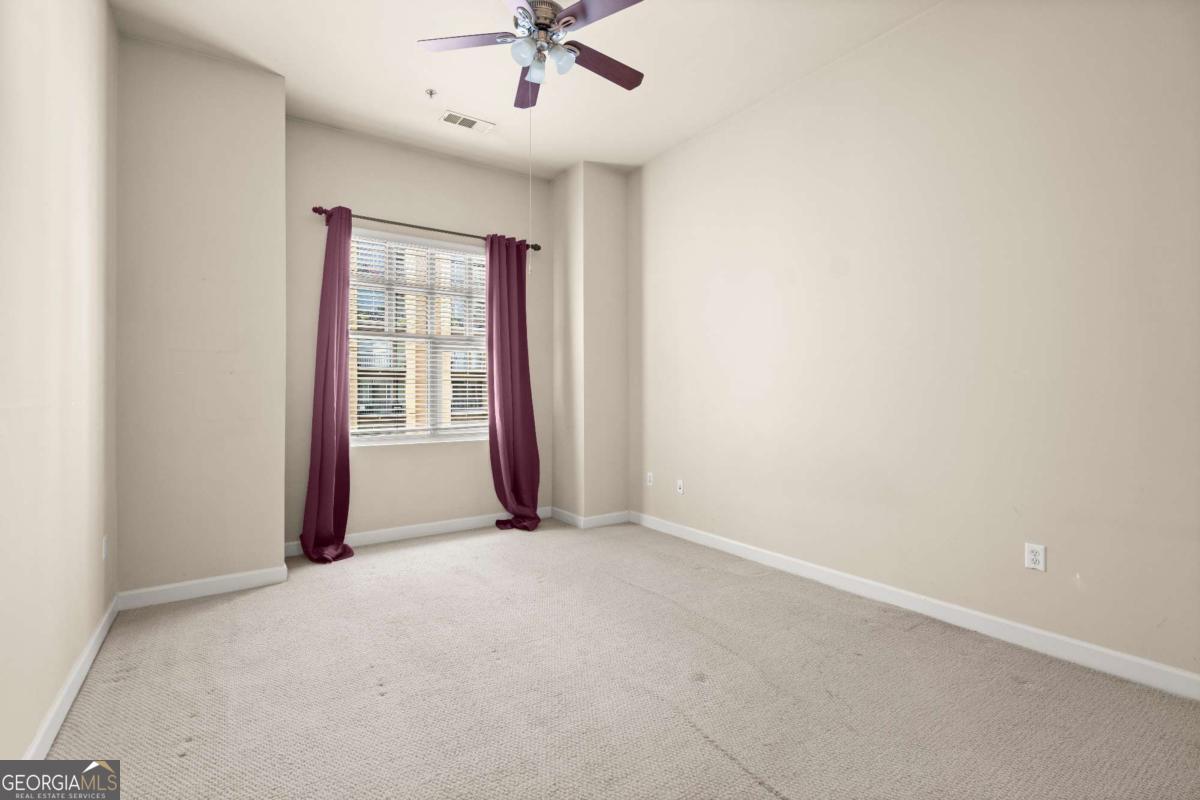 711 Cosmopolitan Drive Northeast, Unit 442 Atlanta, GA 30324 - Photo 10 of 32 an empty room with a window and a ceiling fan