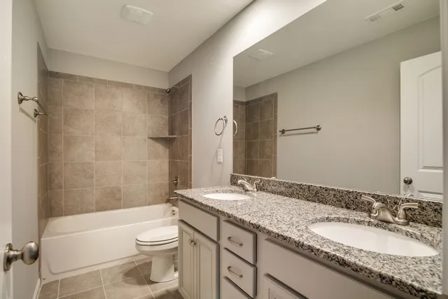 a bathroom with a granite countertop sink toilet mirror and bathtub