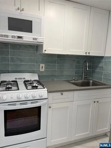a stove top oven sitting inside of a kitchen
