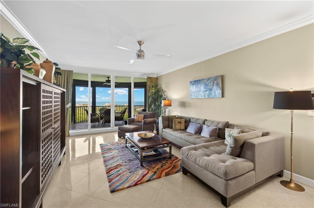 8990 Bay Colony Drive, Unit 1002 Naples, FL 34108 - Photo 4 of 20 a living room with furniture and a floor to ceiling window