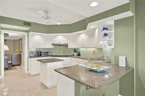 a kitchen with a sink a stove and chairs