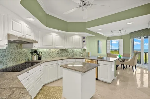 a kitchen with granite countertop a sink a counter top space and stainless steel appliances