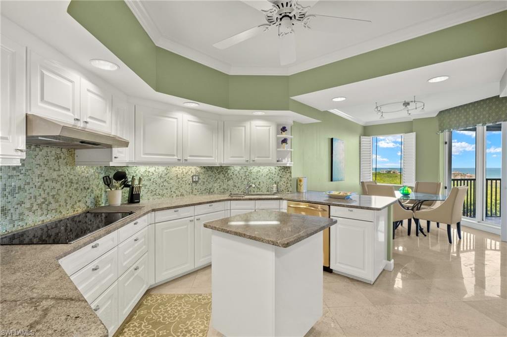 8990 Bay Colony Drive, Unit 1002 Naples, FL 34108 - Photo 7 of 20 a kitchen with granite countertop a sink a counter top space and stainless steel appliances