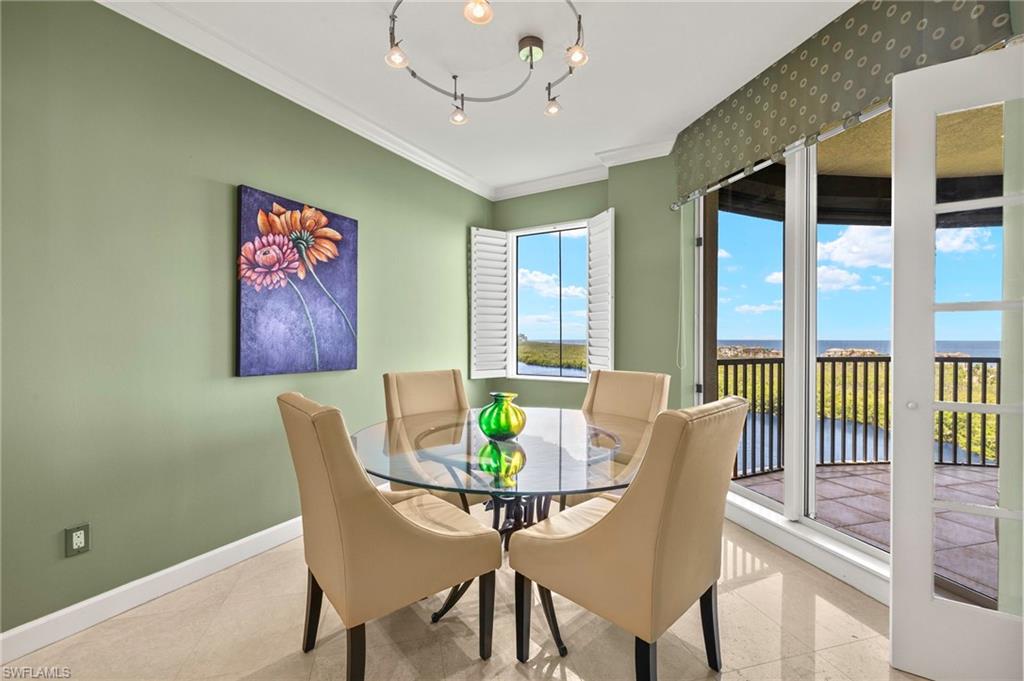 8990 Bay Colony Drive, Unit 1002 Naples, FL 34108 - Photo 9 of 20 a view of a dining room with furniture a chandelier and wooden floor