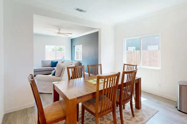 a view of a a dining room with furniture window and wooden floor