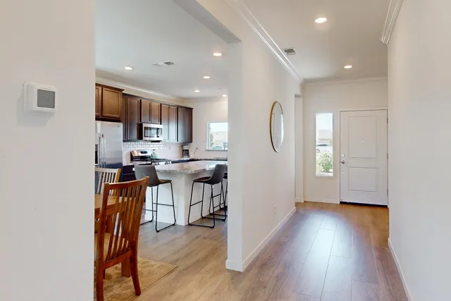 a view of kitchen with stainless steel appliances granite countertop a stove top oven a sink a refrigerator and a microwave