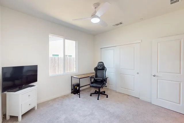 a view of a livingroom with workspace and a window