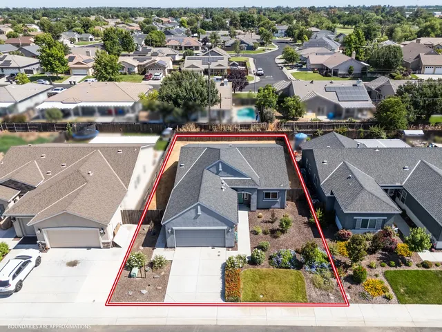 an aerial view of residential houses with outdoor space and parking