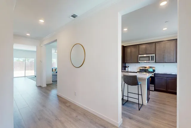 a kitchen with stainless steel appliances granite countertop a refrigerator a stove top oven a sink and dishwasher with wooden floor