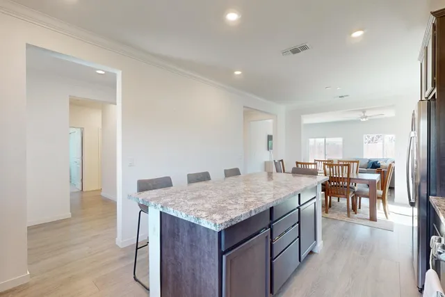 an open kitchen with granite countertop kitchen island a sink dining table and chairs