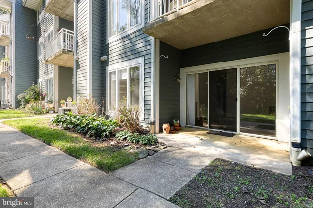 a view of a house with brick walls and a yard with plants